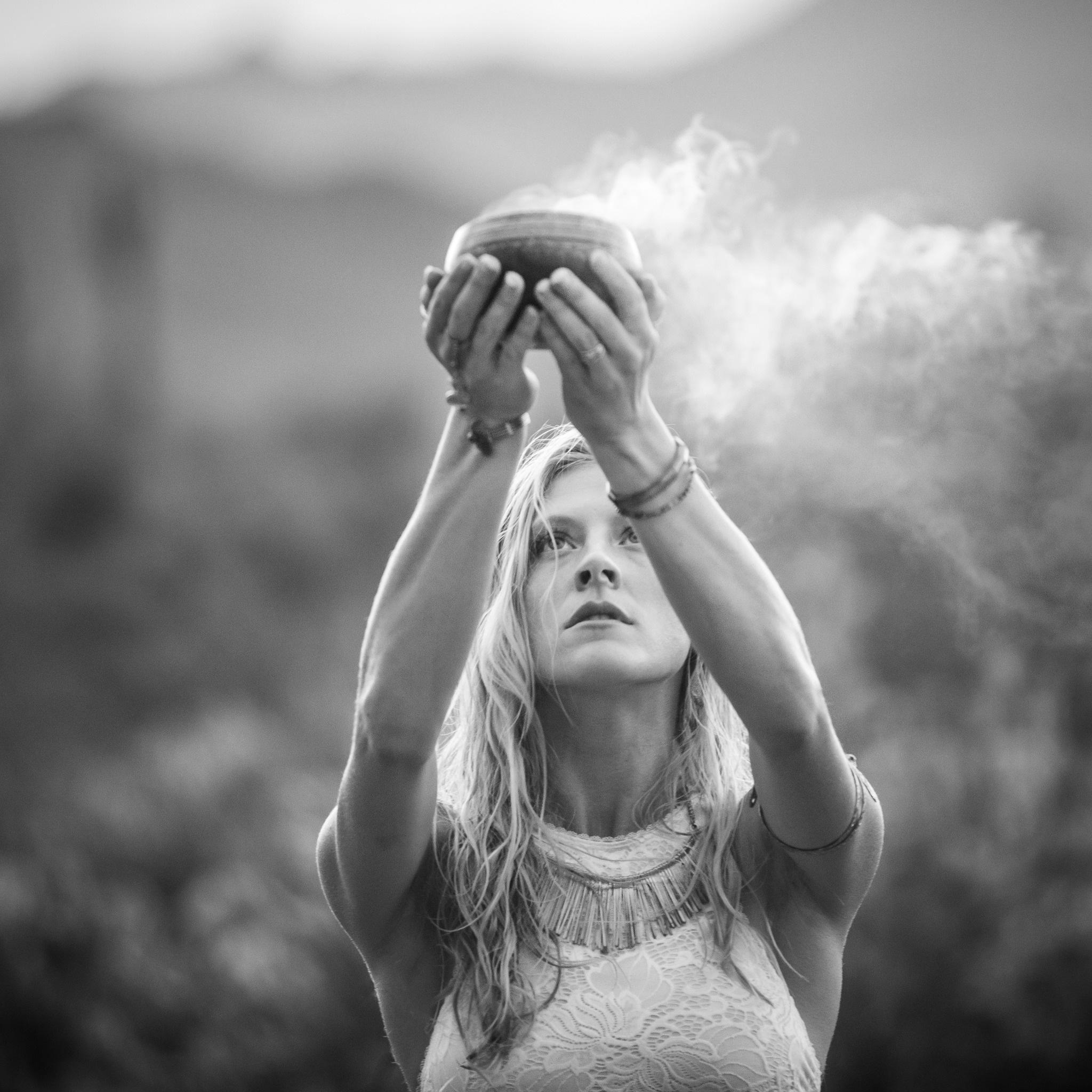Lauren holding a smoking ceremonial bowl beneath the mountains